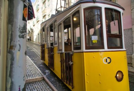 Cultural Symbols - a yellow trolley car on a cobblestone street