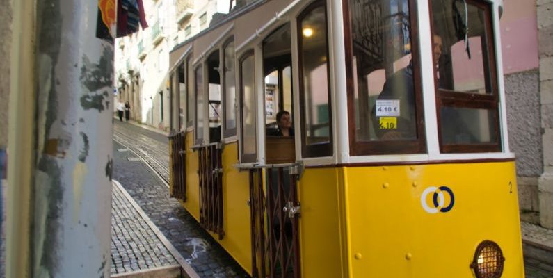 Cultural Symbols - a yellow trolley car on a cobblestone street