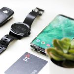 Travel Gadgets - black Android smartphone near round black smartwatch, car fob, leather watch, and green succulent plant