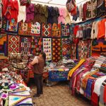 Cusco Peru - woman in store with display of assorted shirts and textiles