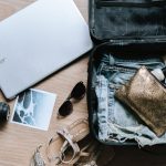 Packing Suitcase - black DSLR camera near sunglasses and bag