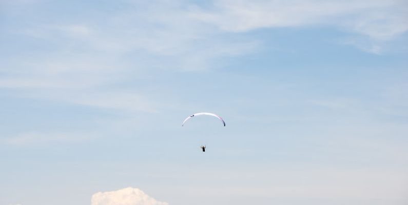 Skydiving Alps - person in parachute under blue sky during daytime