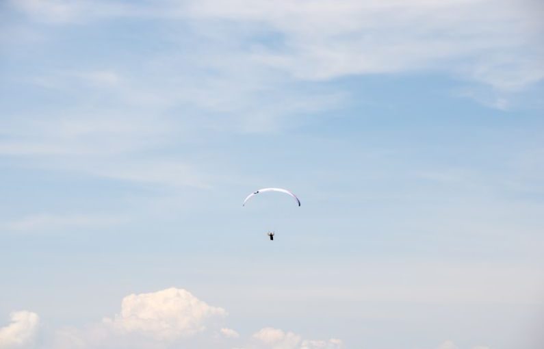 Skydiving Alps - person in parachute under blue sky during daytime