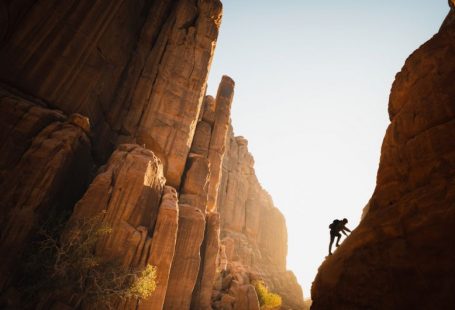 Rock Climbing - a man climbing up the side of a mountain