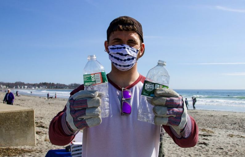 Beach Cleanup - man in white shirt holding bottled water