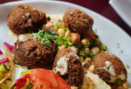 Plant-based Cuisine - a white plate topped with meatballs and a salad