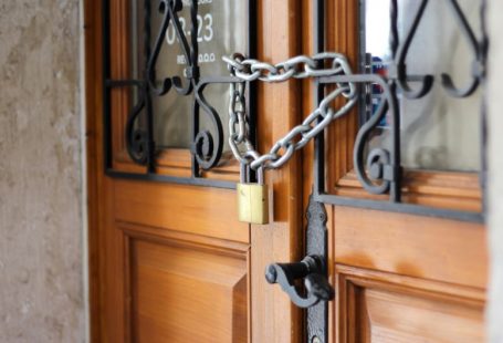 Locked Door - grey metal chain on brown wooden door