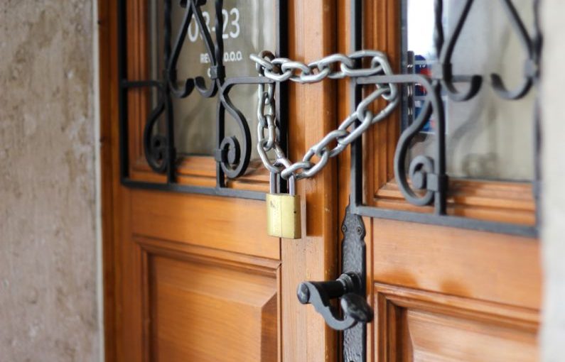 Locked Door - grey metal chain on brown wooden door